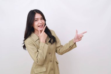 Neşeli genç Endonezya hükümet çalışanı yan tarafı işaret ederken ayakta duruyor