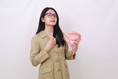 Elinde Endonezya banknotları tutan kibirli memur kadın.
