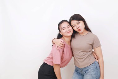 Beyaz arka planda gülümseyen iki güzel Asyalı kadın. Arkadaşlık kavramı