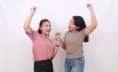 İki kendine güvenen Asyalı kadın ellerini sıkarken ayakta duruyor. Beyaz arkaplanda izole