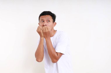 Korkak surat ifadesiyle Asyalı komik adam ayakta duruyor. Kopyalama alanı ile beyaza izole edilmiş