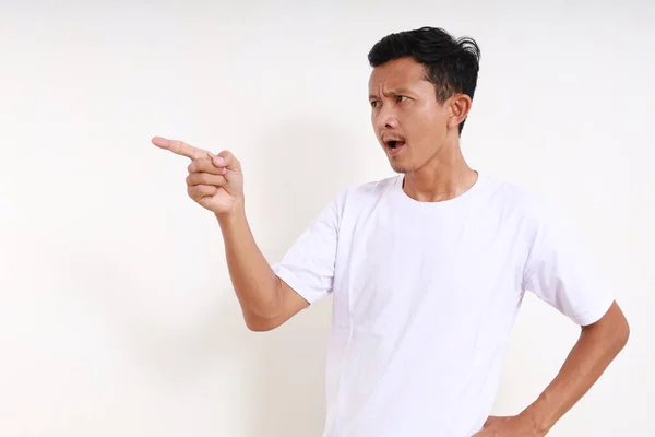 Kızgın Asyalı Komik Adam Yan Tarafı Işaret Ederken Ayakta Duruyor — Stok fotoğraf