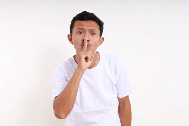 Asyalı komik adam sessiz işaret el hareketleriyle ayakta duruyor. Beyaz arkaplanda izole