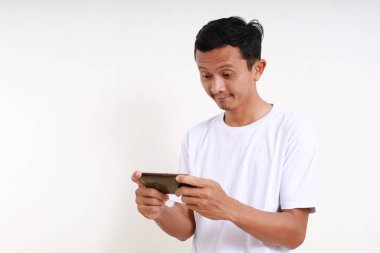 Zeki telefonuyla oyun oynayan Asyalı komik adamın ifadesi. Beyaz arkaplanda izole