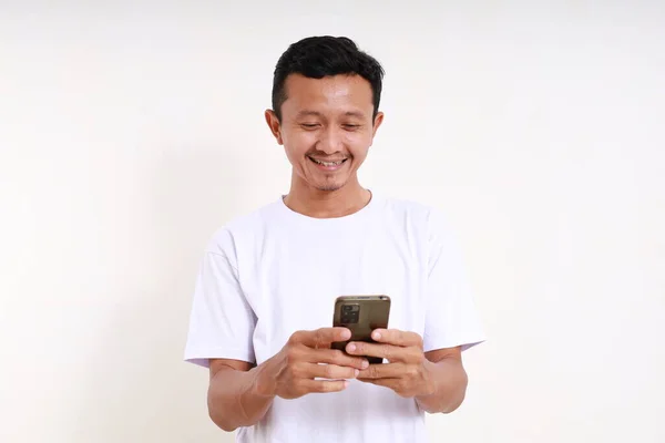 Счастливый Азиатский Смешной Человек Стоит Держа Руках Мобильный Телефон Изолированный — стоковое фото