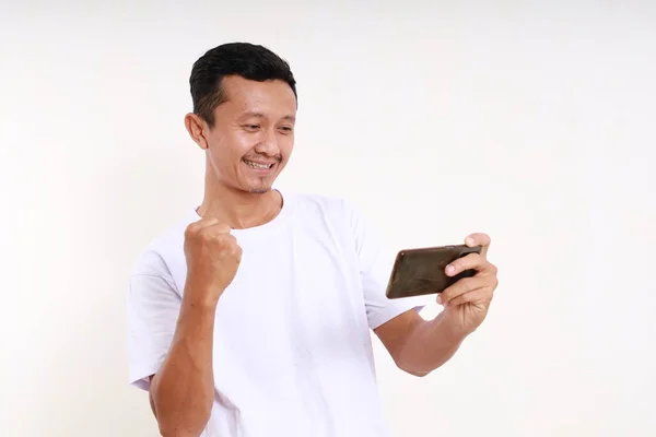 Happy Asian Funny Man Bermain Game Telepon Pintarnya Sambil Mengepalkan — Stok Foto