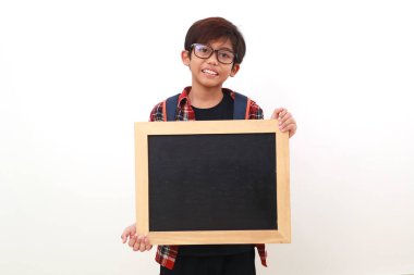 Asyalı mutlu öğrenci elinde boş bir tahtayla ayakta duruyor. Beyazda izole edilmiş