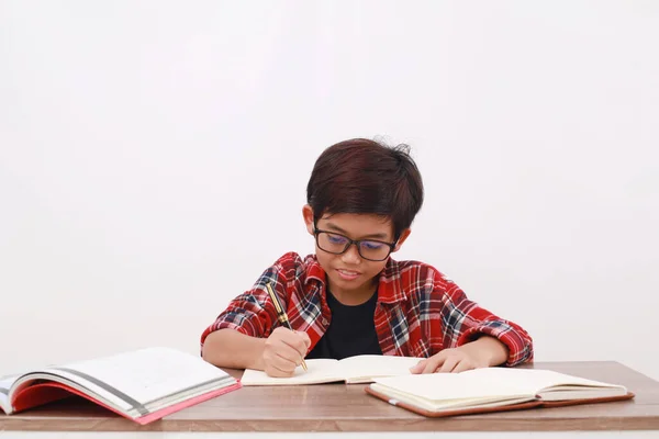 白い背景に隔離された机の上で勉強幸せなアジアの学生 — ストック写真