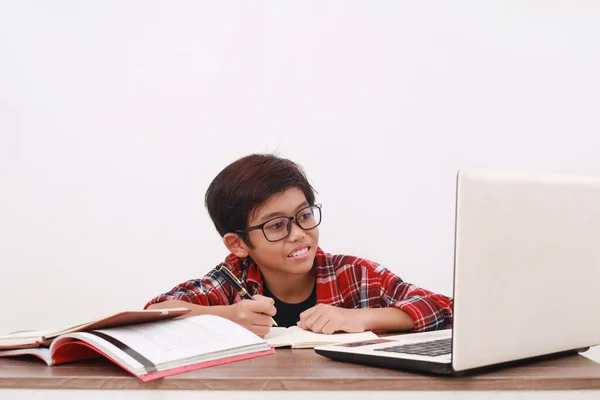 机の上にノートパソコンで勉強している幸せなアジアの学生 白地に隔離された — ストック写真