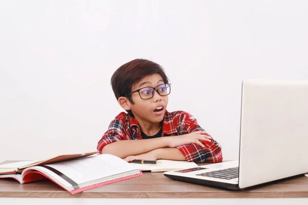 衝撃的なアジアの学生は彼のラップトップコンピュータを使用してオンライン学校を通してレッスンを取る 白に隔離された — ストック写真
