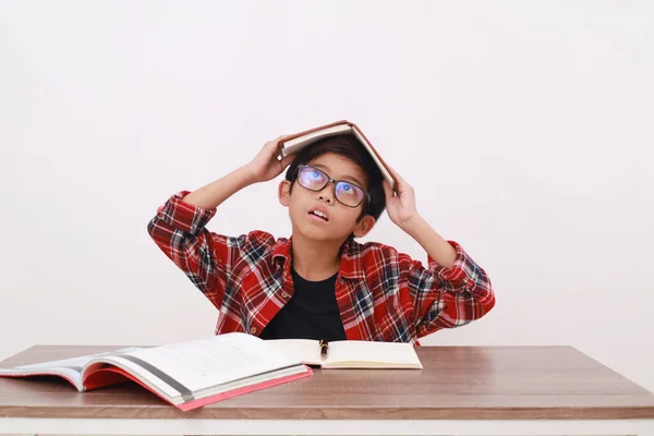 Asyalı Bir Öğrenci Kafasında Kitapla Geleceğini Düşünüyor Beyaz Arkaplanda Izole — Stok fotoğraf