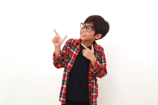 Glad Asiatisk Pojke Stående Medan Pekar Och Tittar Sidan Isolerad — Stockfoto