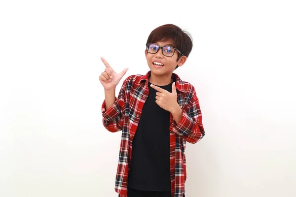 Щасливий Азіатський Хлопчик Стоїть Вказуючи Бік Дивлячись Камеру Ізольовані Білому — стокове фото