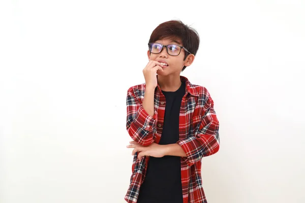 Przemyślany Azjatycki Chłopiec Stojący Gryząc Się Palec Patrząc Bok Odizolowane — Zdjęcie stockowe