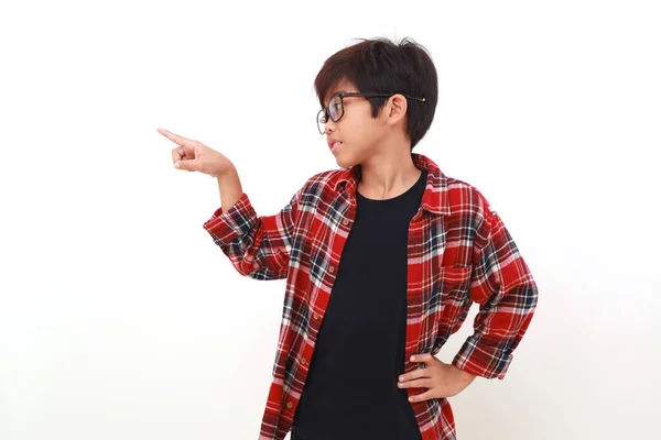 Förtjusande Asiatisk Pojke Som Står Och Pekar Sidled Tomrummet Isolerad — Stockfoto