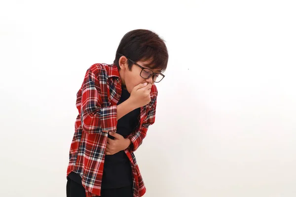 アジア系の少年は腹痛を起こして嘔吐する 白に隔離された — ストック写真