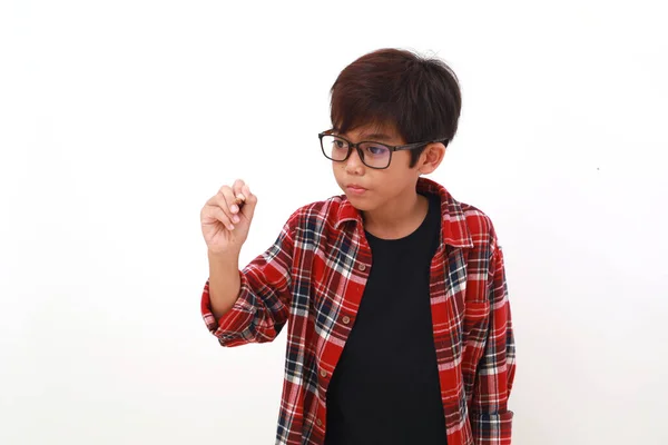 Roztomilý Asijský Chlapec Drží Pero Zatímco Něco Píše Izolováno Bílém — Stock fotografie