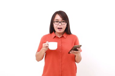 Elinde cep telefonu ve bir fincan kahveyle ayakta duran Asyalı genç bir kadın şok oldu.