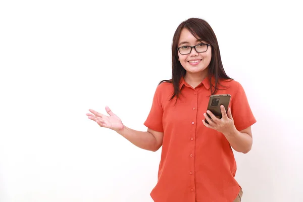 Yanında Bir Şey Sunarken Elinde Cep Telefonu Tutan Mutlu Asyalı — Stok fotoğraf