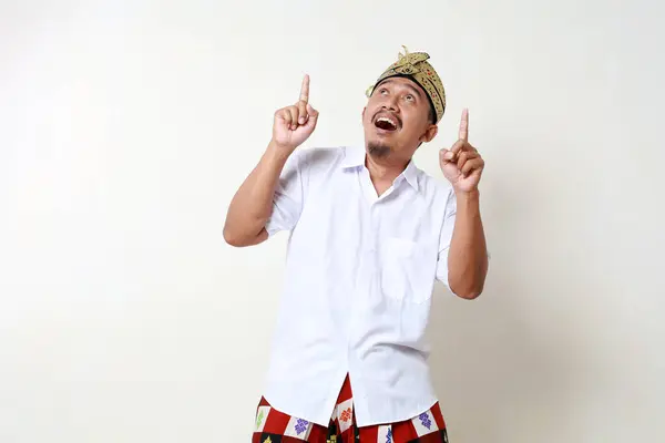 Азиатский Мужчина Балийском Традиционном Костюме Стоит Указывая Выше Изолированный Белом — стоковое фото