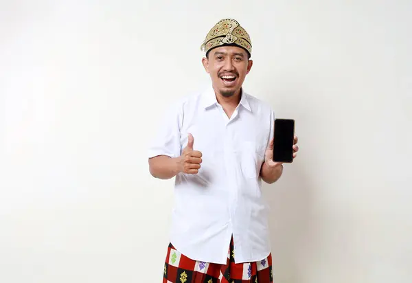 Возбужденный Азиат Балийском Традиционном Костюме Показывает Чистый Экран Мобильного Телефона — стоковое фото