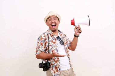 Asyalı yetişkin turistin elinde megafonla kameraya bakarken heyecanlı yüz ifadesi. Seyahat kavramı. Beyaz arkaplanda izole