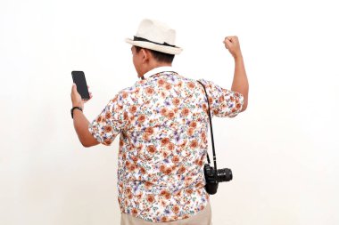 Arka planda Asyalı gezgin cep telefonunu yumrukla tutarken görülüyor. Kopyalama alanı ile beyaz arkaplanda izole