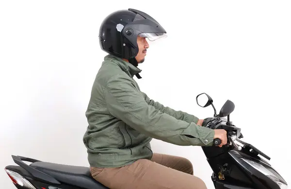 バイクを運転するアジア人男性の側面 白い背景に隔離される — ストック写真