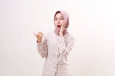 Yanında bir şey sunan Asyalı genç Müslüman kadının heyecanlı ifadesi. Beyazda izole edilmiş