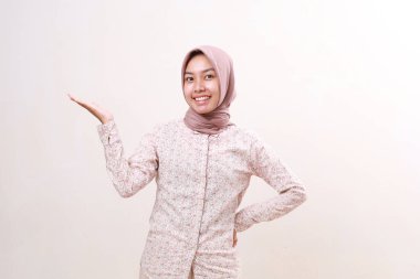 Boş uzayda onun yanında sunum yapan mutlu Asyalı genç Müslüman kız. Beyazda izole edilmiş