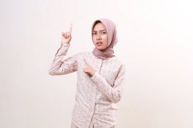 Kafası karışmış genç Asyalı Müslüman kadın yukarıda dikiliyor. Beyazda izole edilmiş