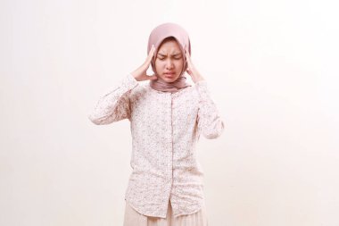 Genç Asyalı Müslüman kadın baş ağrısı çekiyor. Eller başınızı tutuyor. Beyaz arkaplanda izole