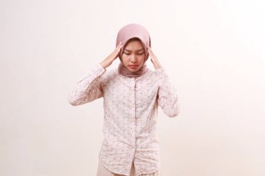 Genç Asyalı Müslüman kadının kafasında sorun var. Kafasını tutuyordu. Beyazda izole edilmiş