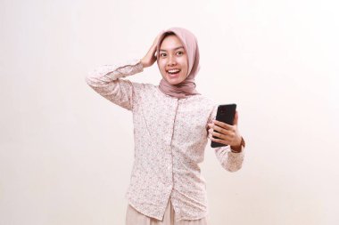 Vay canına, genç Asyalı kızın elinde inanılmaz bir yüz ifadesi olan bir cep telefonu tutmasına şaşırdım. Beyaz arkaplanda izole