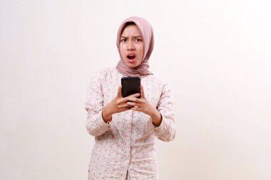 Cep telefonu tutarken bağıran Asyalı genç müslüman kadın hayal kırıklığına uğradı. Beyazda izole edilmiş