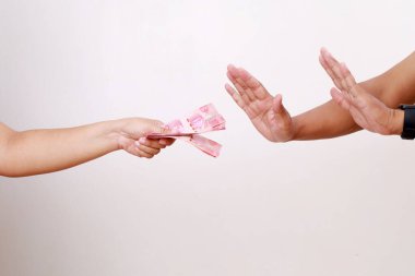 Bir insanın eli, reddeden diğer ele bir yığın para verir. Yan görüş. Beyaz arka plan. Dünya Yolsuzlukla Mücadele Günü