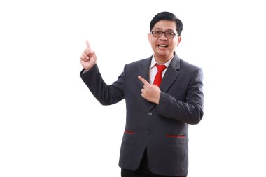 Asyalı mutlu işadamı yan tarafı işaret ederken ayakta duruyor. Beyazda izole edilmiş