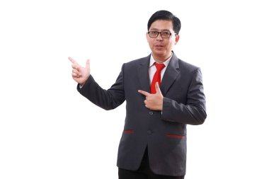 Asyalı mutlu işadamı yan tarafı işaret ederken ayakta duruyor. Beyazda izole edilmiş