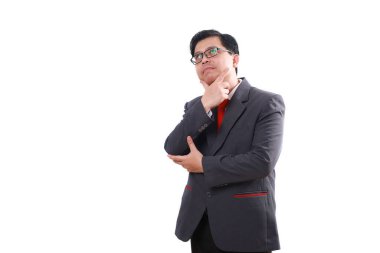 Düşünceli Asyalı iş adamı bir fikir düşünürken ayakta duruyor. Beyazda izole edilmiş