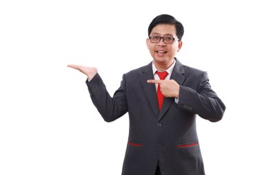 Kendine güvenen Asyalı işadamı bir şey sunarken ayakta duruyor. Beyaz arkaplanda izole