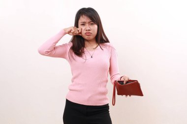 Sad young asian girl crying while holding an empty wallet. Isolated on white background