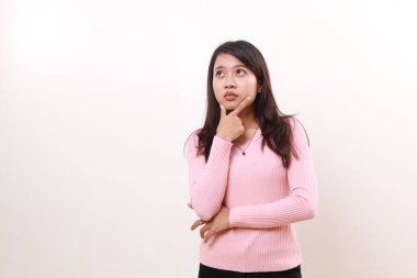 Thoughtful young asian girl standing while thinking and imagining an idea. Isolated on white background
