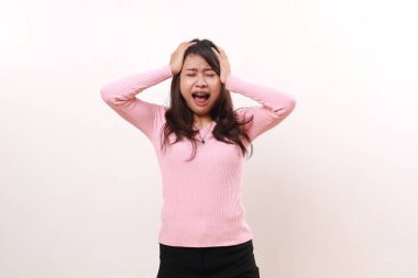 Stressed depressed young asian girl holding head while crying. Isolated on white background