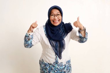 Asyalı, yaşlı Müslüman kadının baş parmağını gösteren portresi. Beyazda izole edilmiş