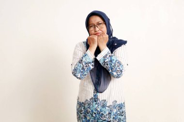 Üzgün Asyalı yaşlı Müslüman kadın portresi hayal kırıklığına uğramış yüz ifadesiyle ayakta duruyor.