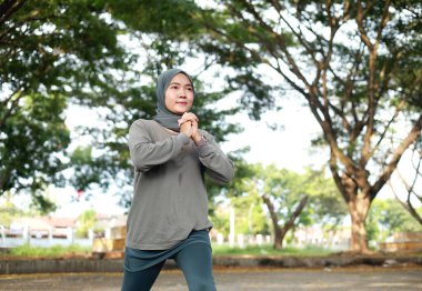 Tesettürlü sağlıklı Asyalı kadın portresi sabah parkta egzersiz yapıyor.