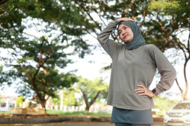 Genç Asyalı Müslüman kadın parkta başını uzatıyordu.