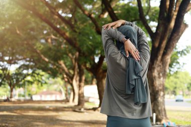 Spor giyim kuşağında genç Asyalı atletik kız antrenmandan önce geriniyor.