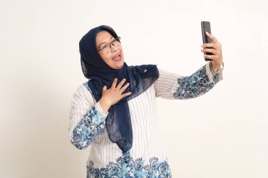 Neşeli heyecanlı Asyalı yaşlı kadın elinde cep telefonuyla ayakta duruyor. Rahatlamış konsept