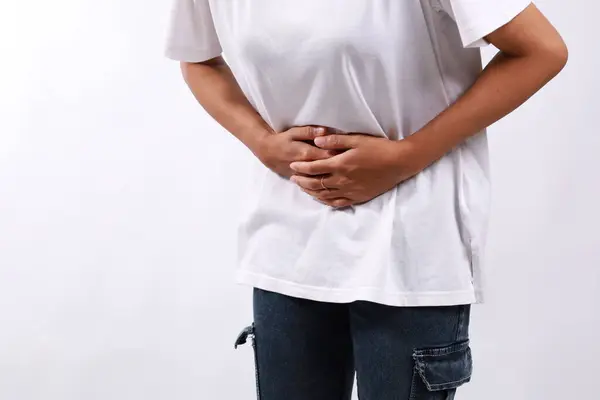 stock image Close up photo of woman's hand holding stomach. Stomach ache concept